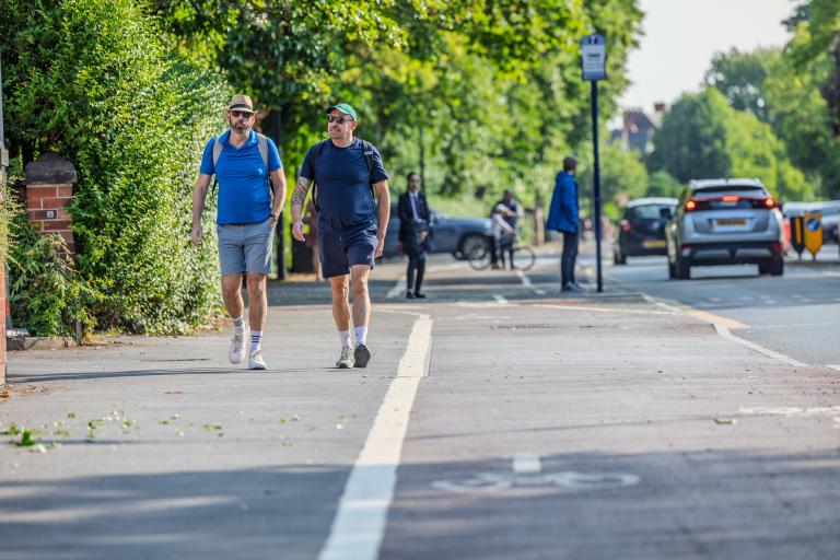 Two people walking on pavement next to cycle lane Doncaster