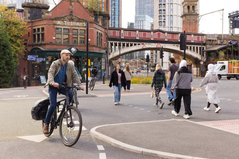 Pedestrians and cyclists crossing busy urban road