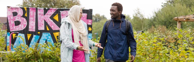 Two pedestrians walk on colourful path